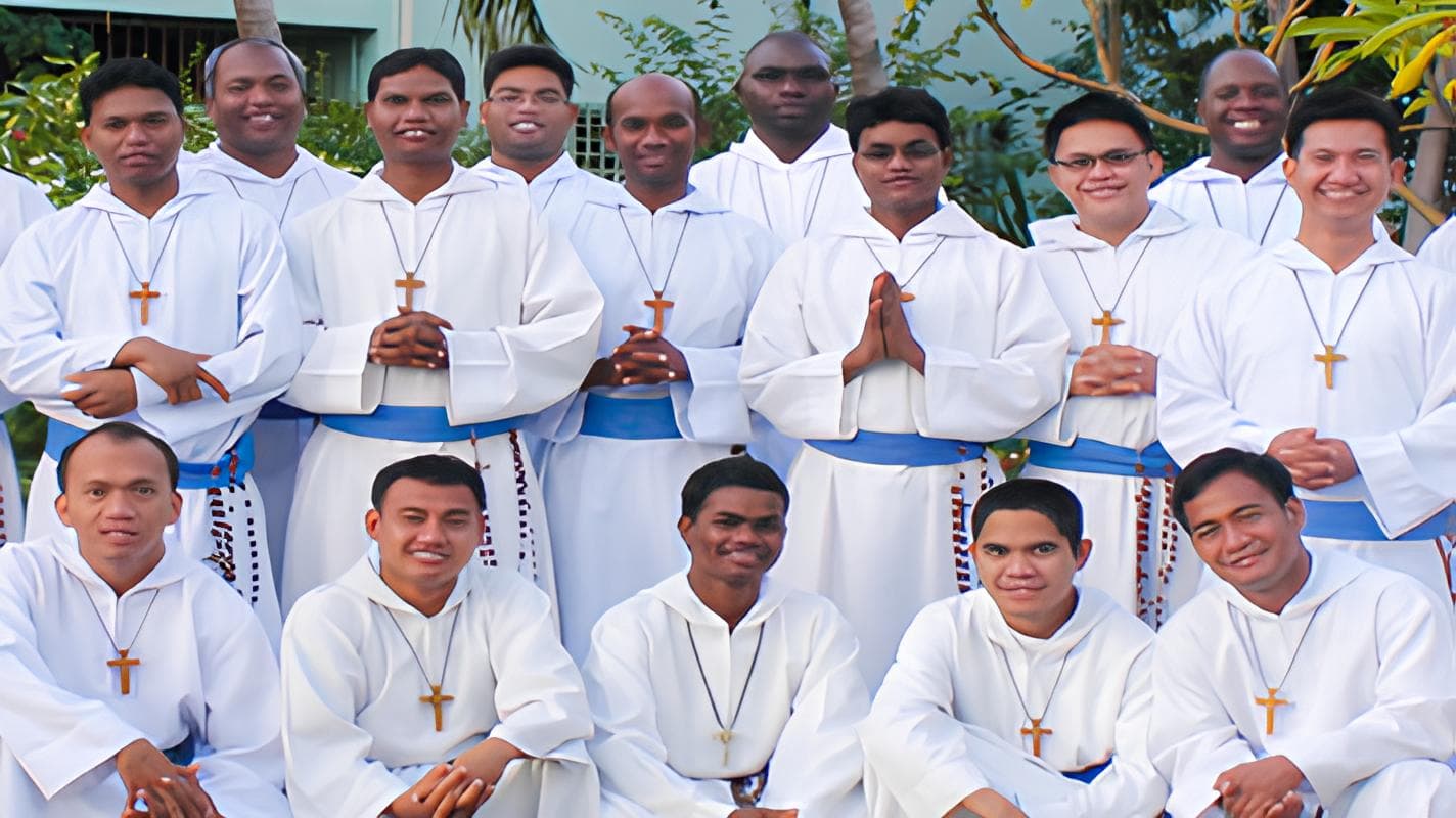 Brothers of the Missionaries of the Poor in white habits gathered for a group photograph
