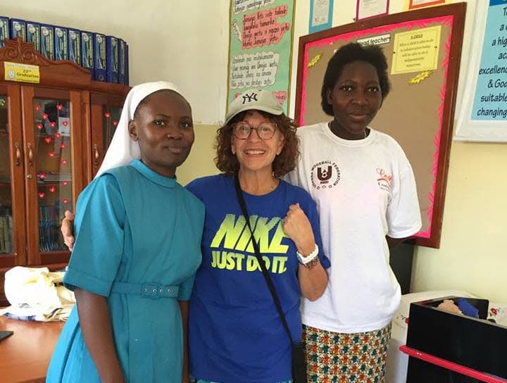A religious sister, a visitor and a young resident together in a classroom at Kyasira Home of Hope